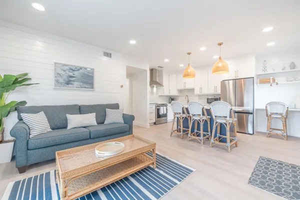 a living room with lots of furniture and kitchen view