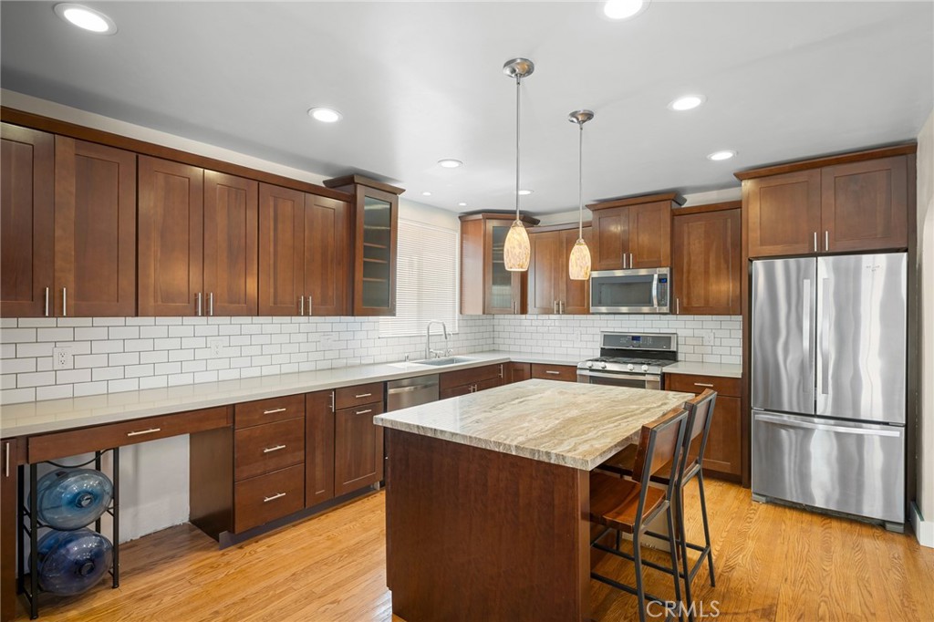 635 Arden Avenue Glendale, CA 91202 - Photo 12 of 36 a kitchen with a sink a kitchen island wooden floor and stainless steel appliances