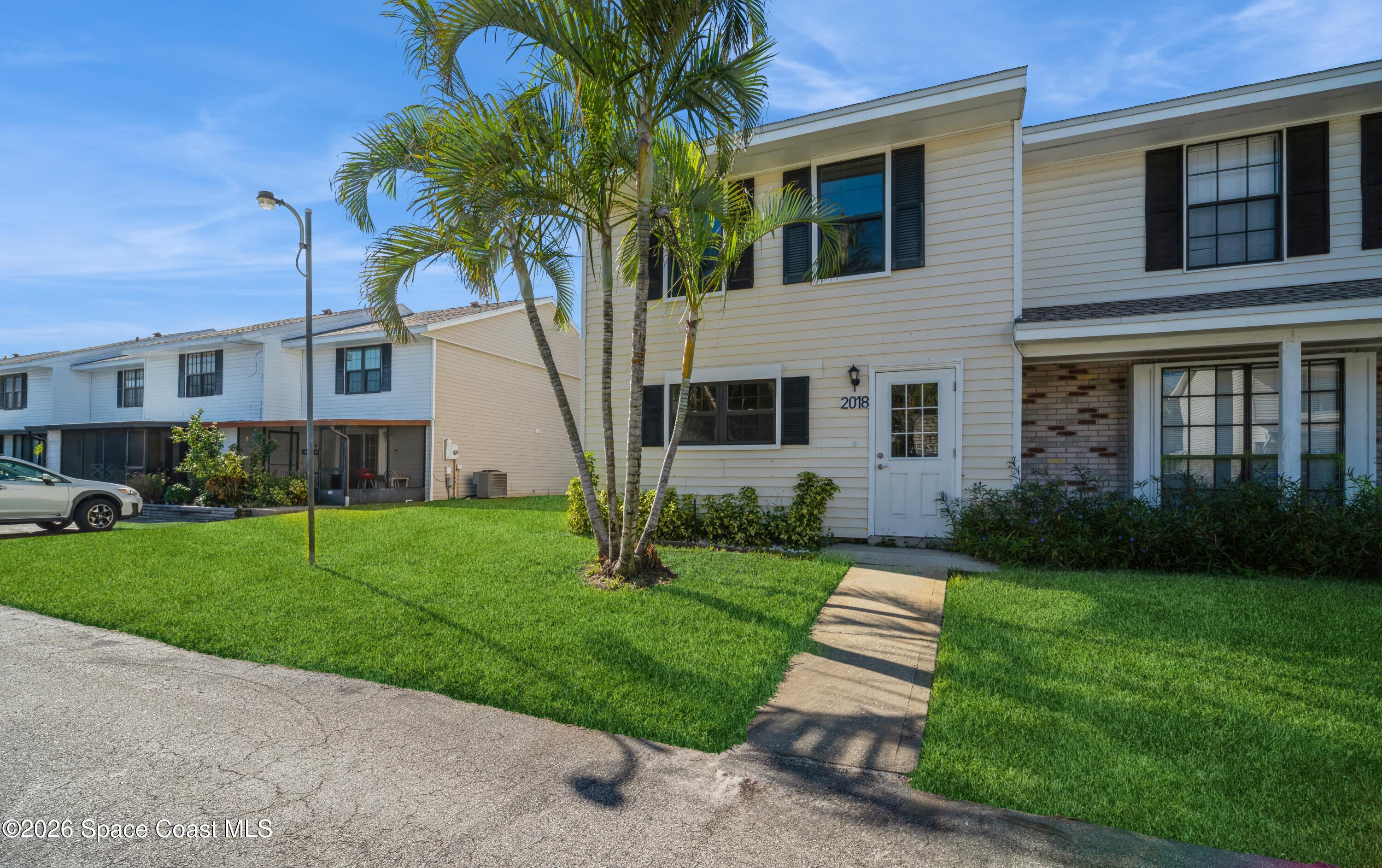 2018 Manor Drive Northeast Palm Bay, FL 32905 - Photo 1 of 29 a front view of a house with a garden and yard