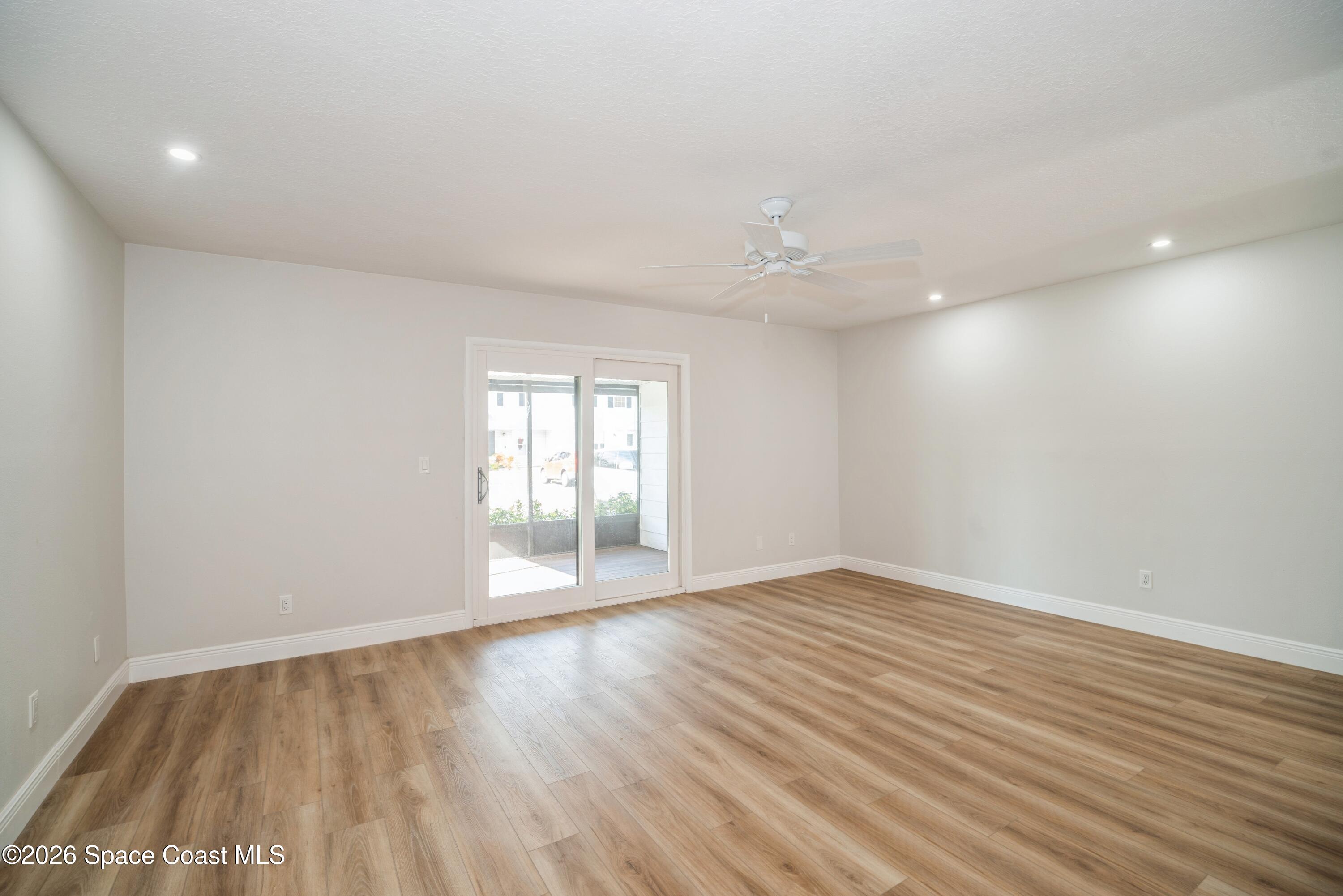 2018 Manor Drive Northeast Palm Bay, FL 32905 - Photo 11 of 29 a view of an empty room with wooden floor and a window