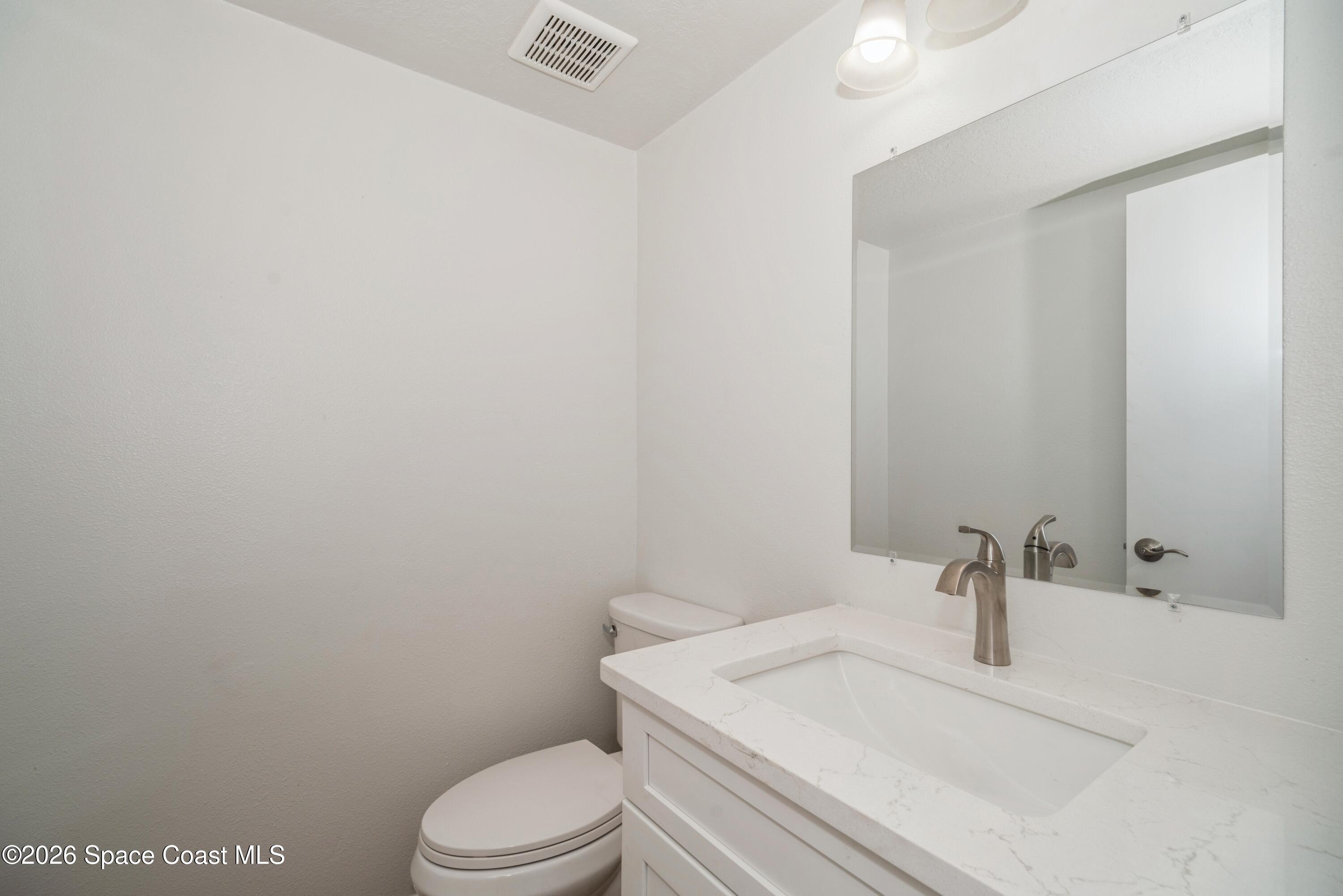 2018 Manor Drive Northeast Palm Bay, FL 32905 - Photo 15 of 29 a bathroom with a sink a toilet and mirror