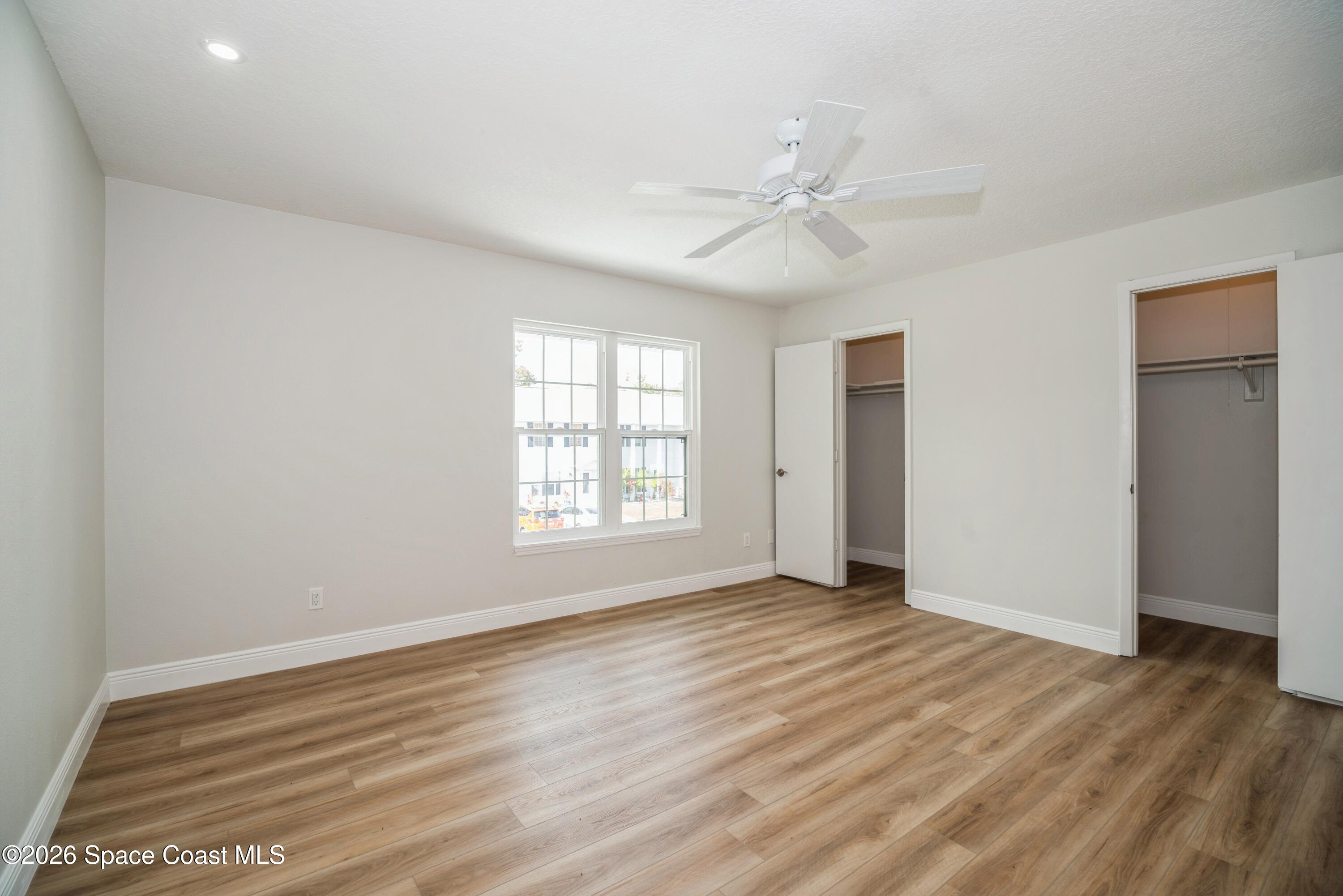 2018 Manor Drive Northeast Palm Bay, FL 32905 - Photo 18 of 29 a view of an empty room with wooden floor and a window