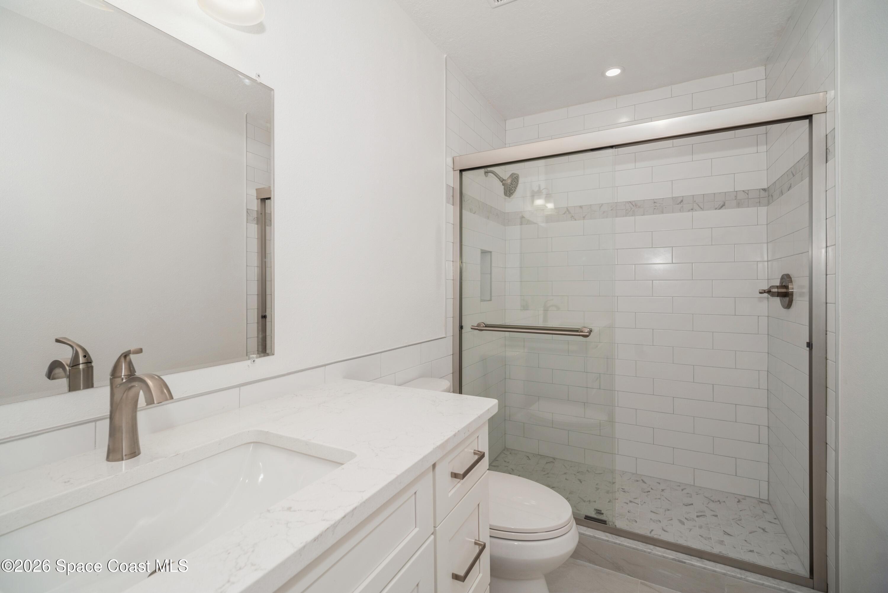 2018 Manor Drive Northeast Palm Bay, FL 32905 - Photo 20 of 29 a bathroom with a granite countertop sink toilet and shower