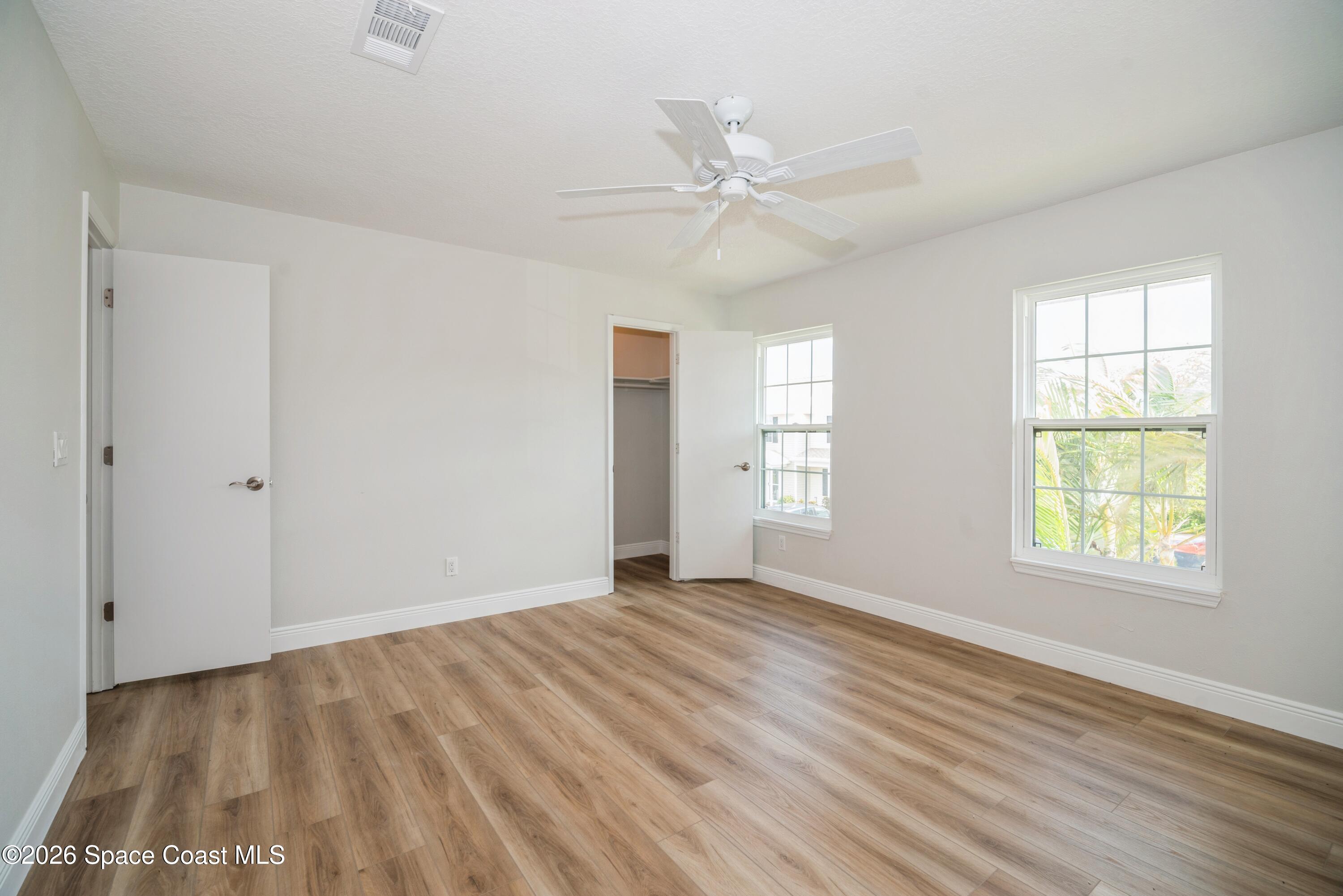 2018 Manor Drive Northeast Palm Bay, FL 32905 - Photo 23 of 29 an empty room with wooden floor closet and windows