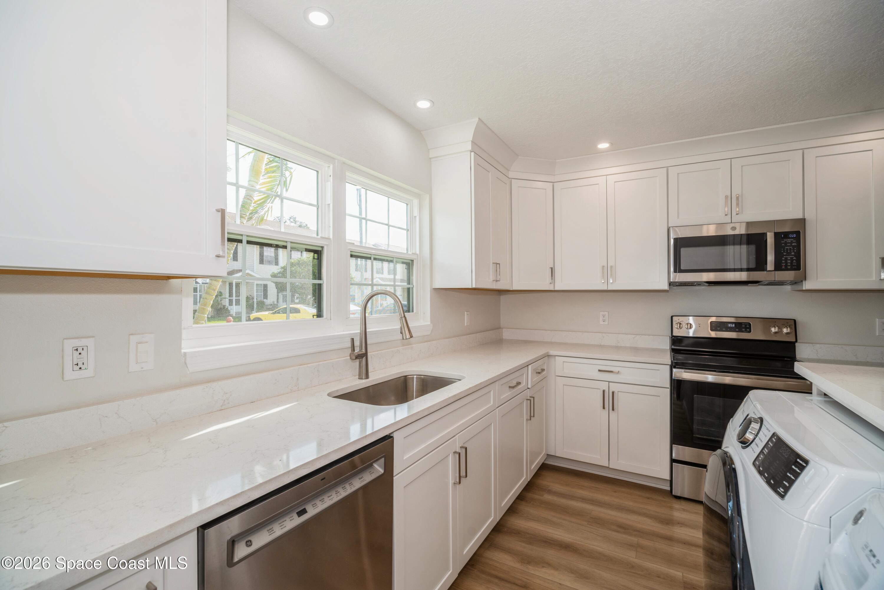 2018 Manor Drive Northeast Palm Bay, FL 32905 - Photo 6 of 29 a kitchen that has a sink and a stove in it