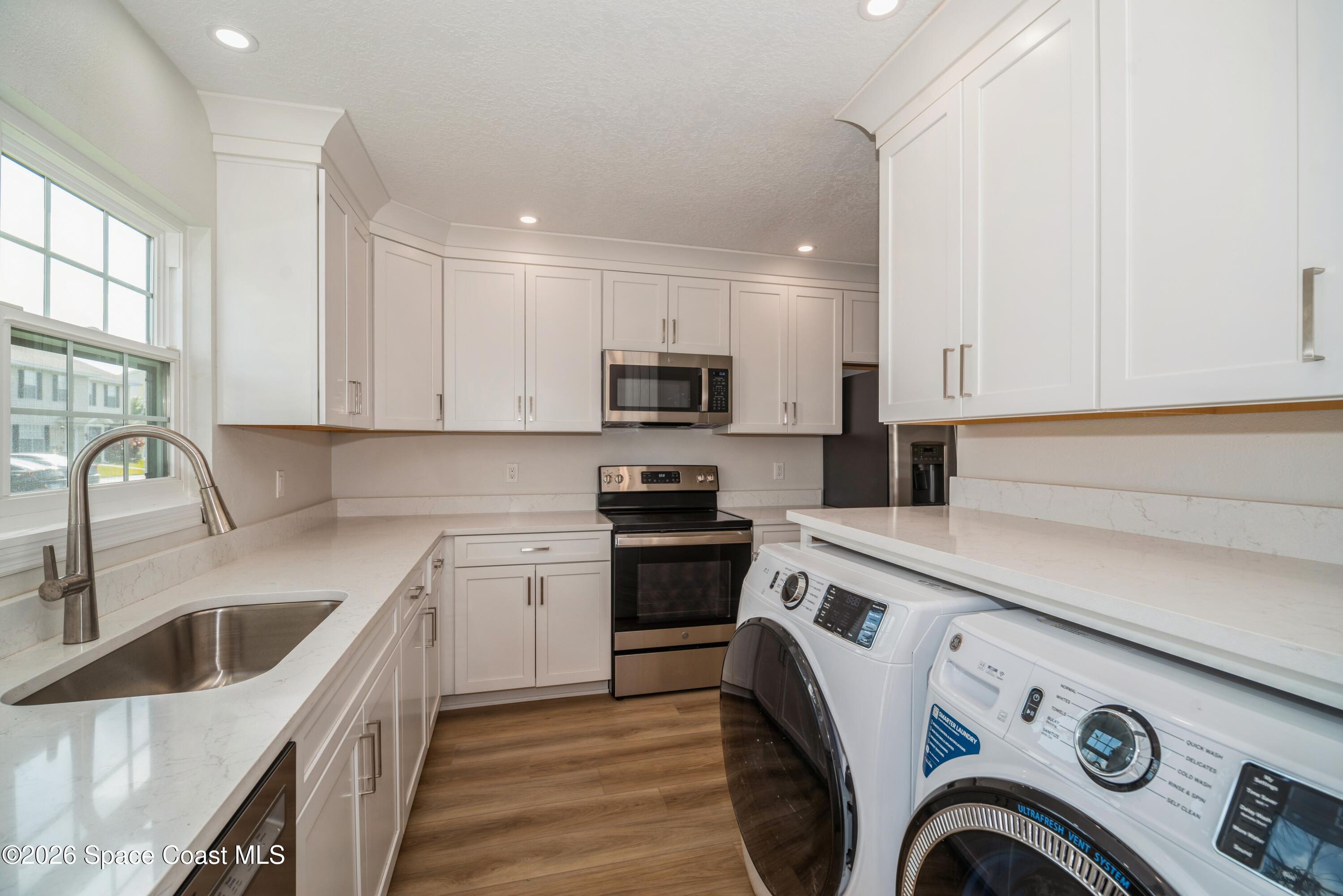 2018 Manor Drive Northeast Palm Bay, FL 32905 - Photo 7 of 29 a kitchen with a sink a stove top oven and cabinets