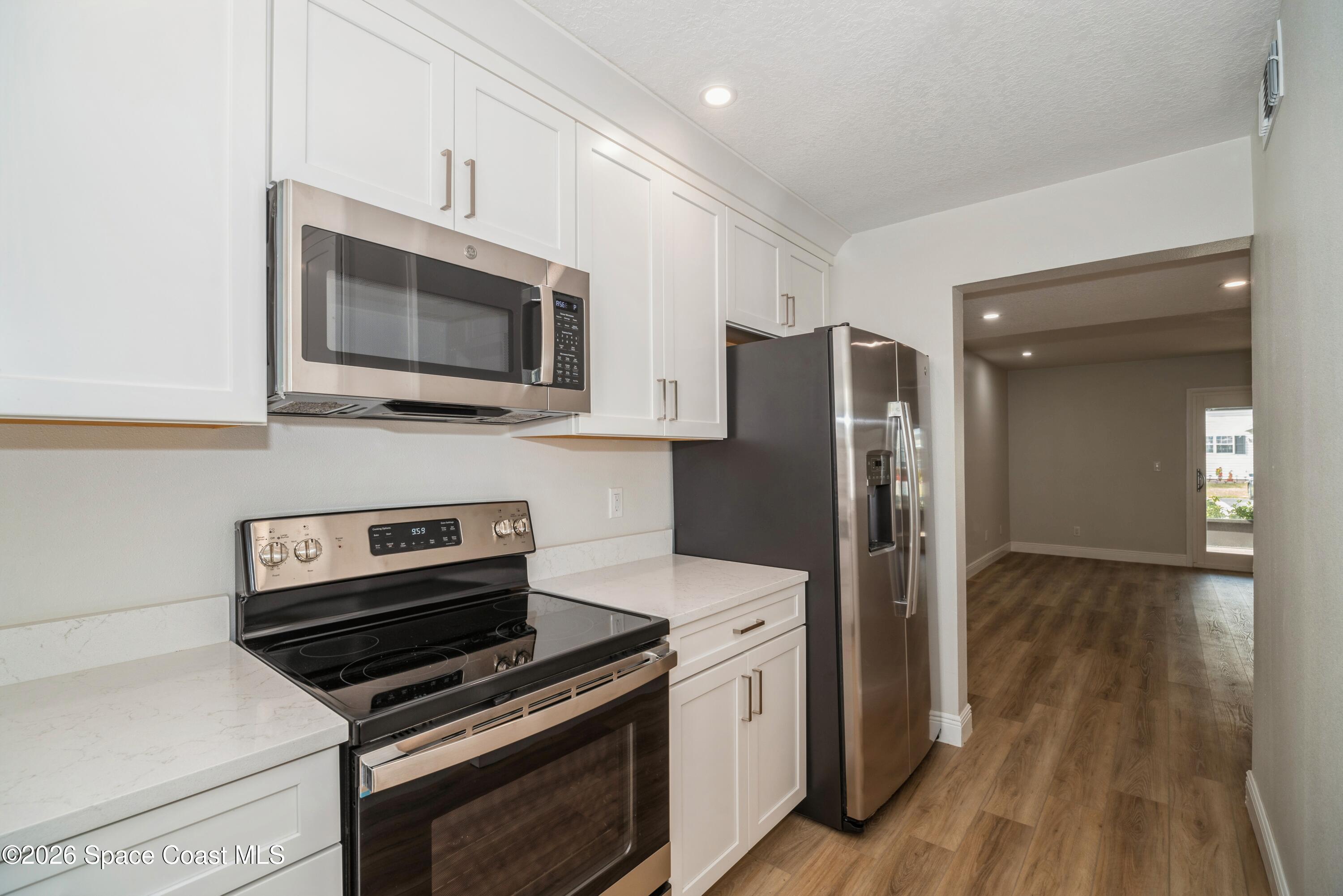 2018 Manor Drive Northeast Palm Bay, FL 32905 - Photo 9 of 29 a kitchen with stainless steel appliances a stove microwave and refrigerator