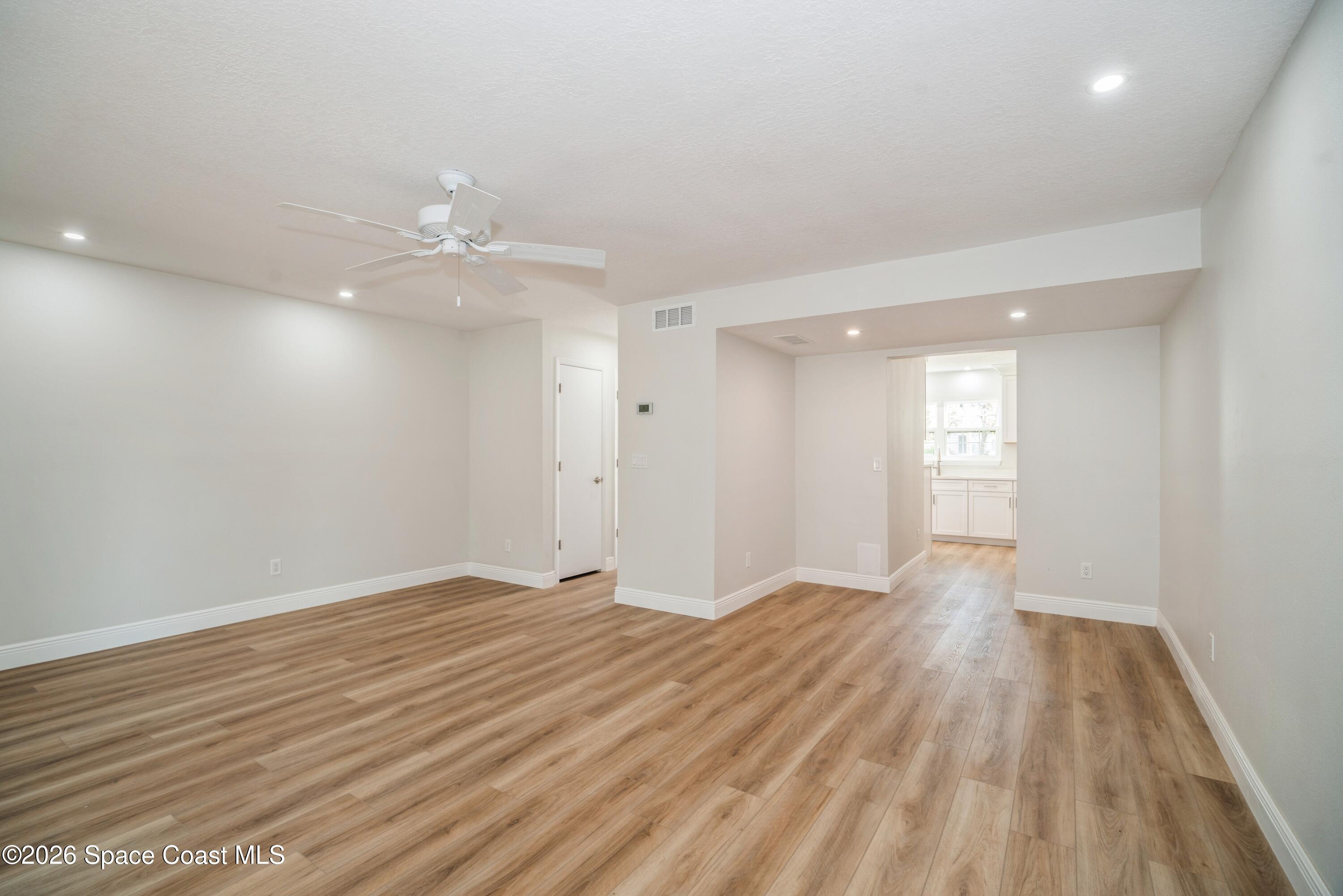 2018 Manor Drive Northeast Palm Bay, FL 32905 - Photo 10 of 29 a view of an empty room with wooden floor and a window