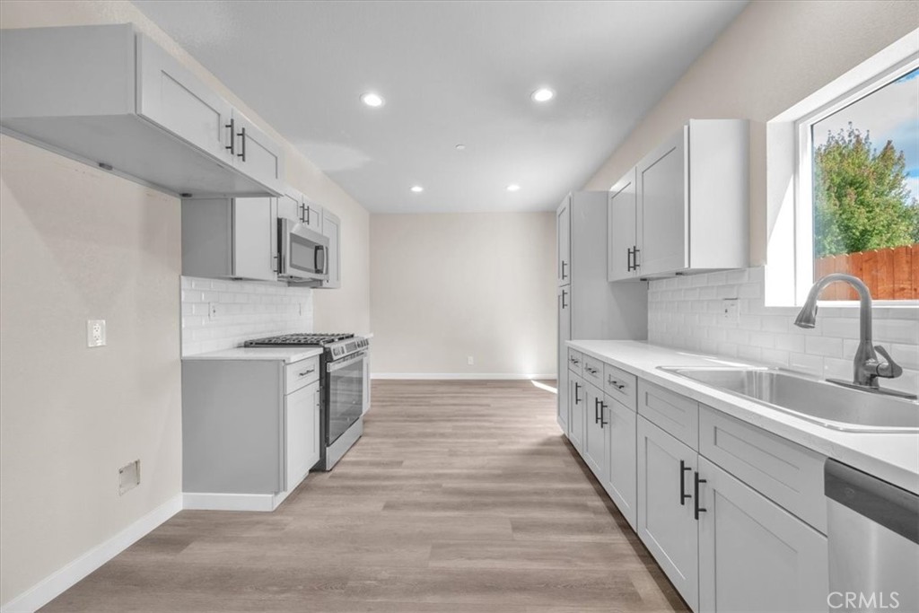 8395 Amapoa Atascadero, CA 93422 - Photo 7 of 22 a large white kitchen with a sink and dishwasher stove a refrigerator with white cabinets