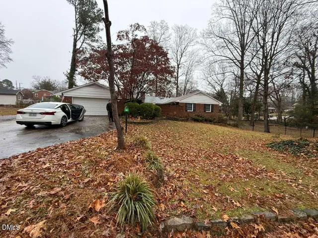 a front view of a house with a yard and tree s