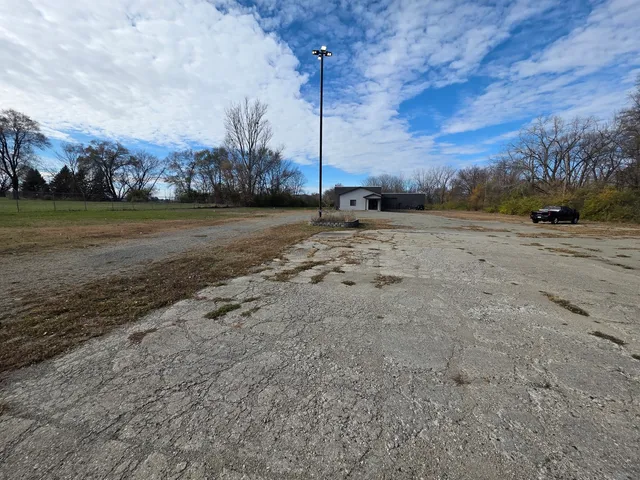a view of dirt field with trees in background