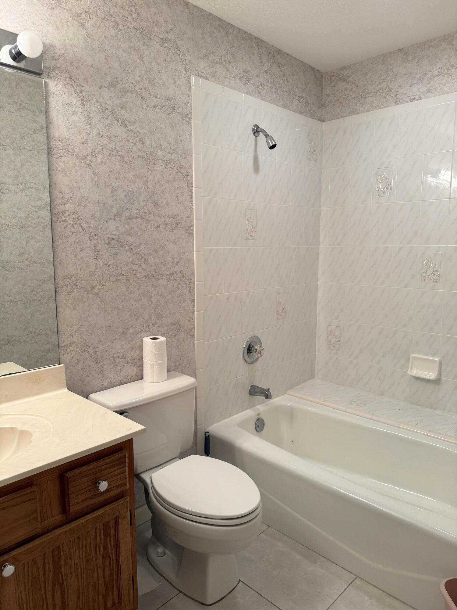 6539 Southeast Held Court Stuart, FL 34997 - Photo 12 of 34 a bathroom with a sink a toilet and bathtub