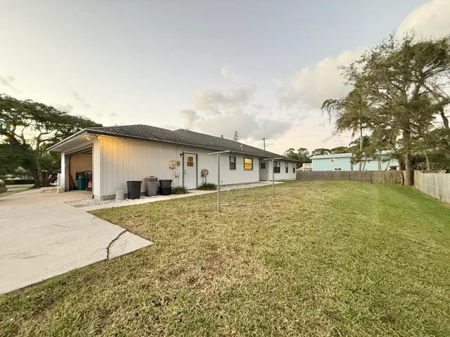 a front view of house with yard and trees around