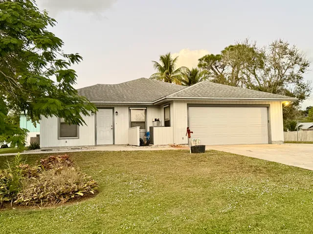 a front view of a house with a garden and yard