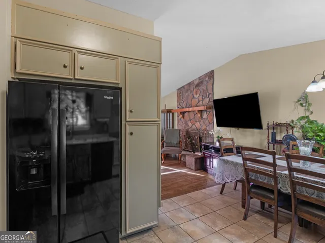 a living room with stainless steel appliances furniture a fireplace and a flat screen tv