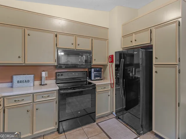 a kitchen with stainless steel appliances a refrigerator stove and cabinets