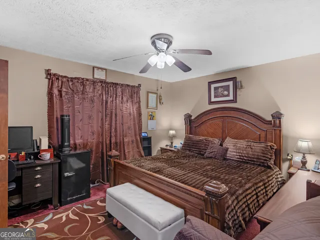 a bedroom with a bed dresser and a chandelier