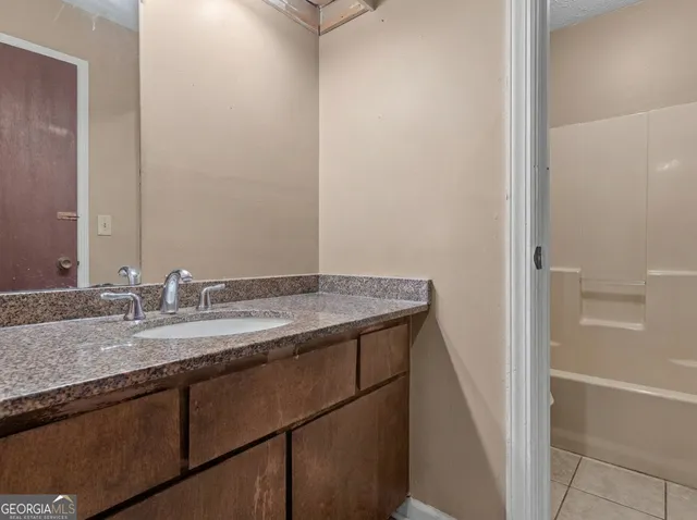a bathroom with a granite countertop sink and a mirror