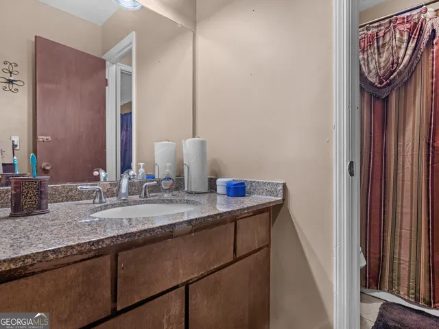 a bathroom with a granite countertop sink and a mirror