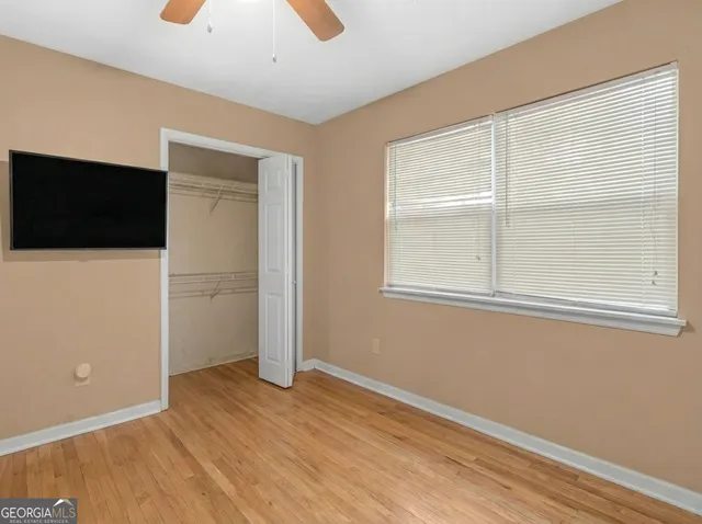 an empty room with wooden floor and windows
