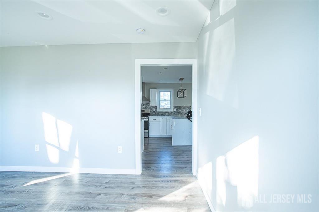 213 Summerhill Road Spotswood, NJ 08884 - Photo 11 of 21 a view of a hallway view with wooden floor and a living room
