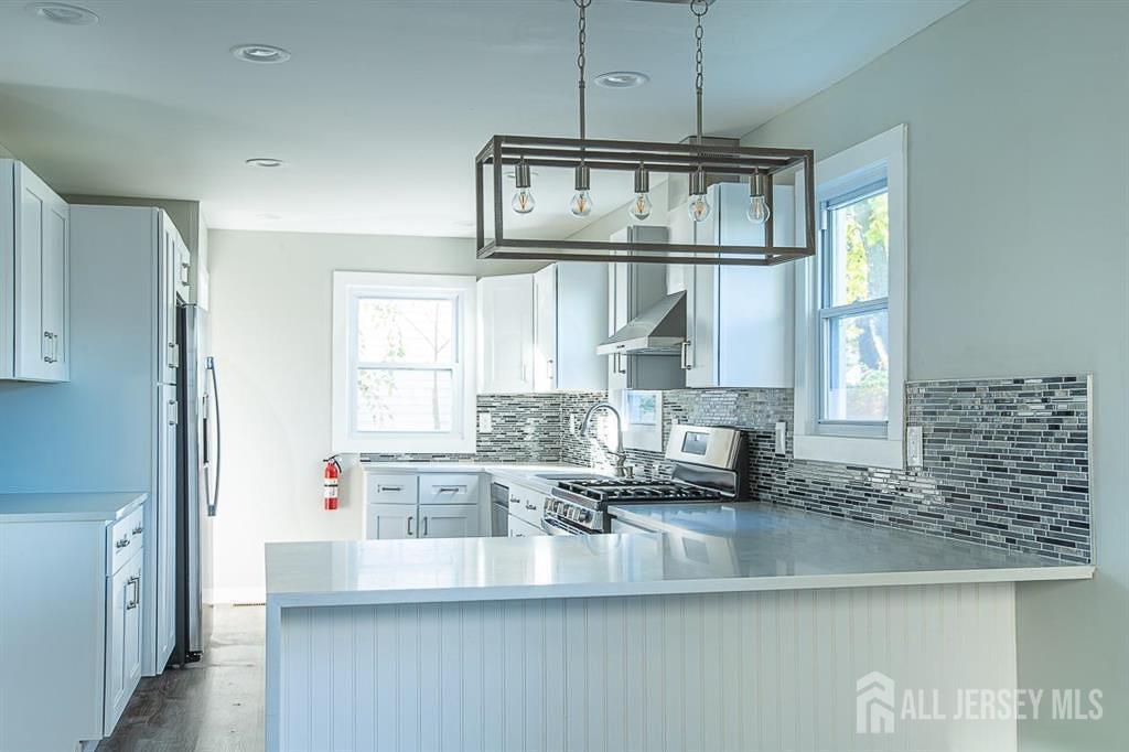 213 Summerhill Road Spotswood, NJ 08884 - Photo 2 of 21 a kitchen with kitchen island granite countertop a sink cabinets and window