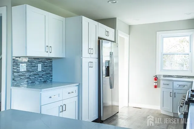 a kitchen with white cabinets and refrigerator