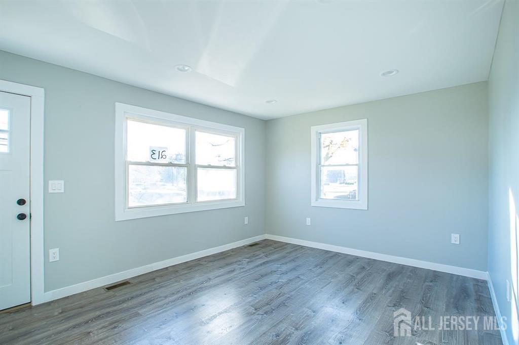 213 Summerhill Road Spotswood, NJ 08884 - Photo 9 of 21 a view of an empty room with wooden floor and a window