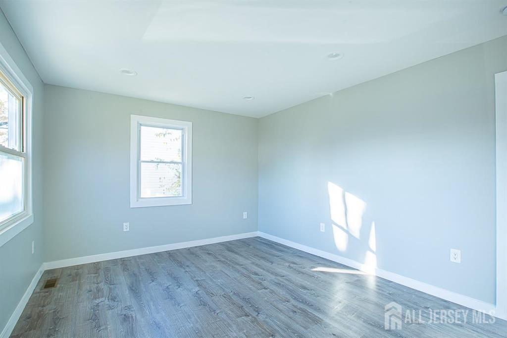 213 Summerhill Road Spotswood, NJ 08884 - Photo 10 of 21 an empty room with wooden floor and windows