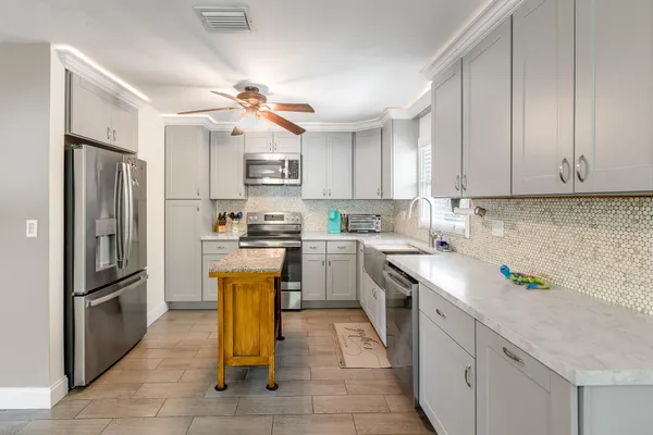 a kitchen with cabinets a refrigerator and a sink