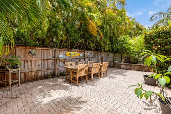 a view of a patio with table and chairs potted plants and wooden fence