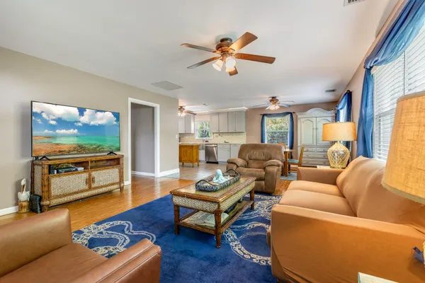 a living room with furniture and a flat screen tv with wooden floor