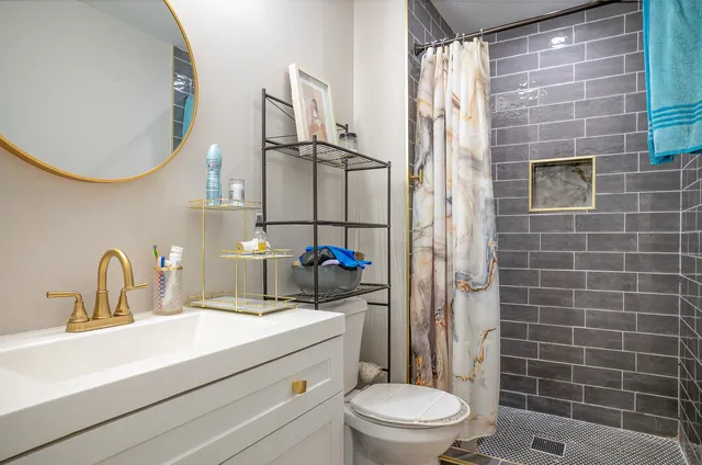 a bathroom with a sink a toilet and shower