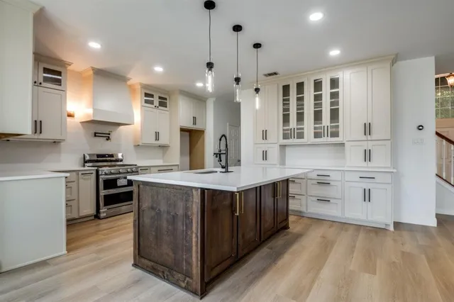 a large kitchen with stainless steel appliances granite countertop a stove oven and a sink