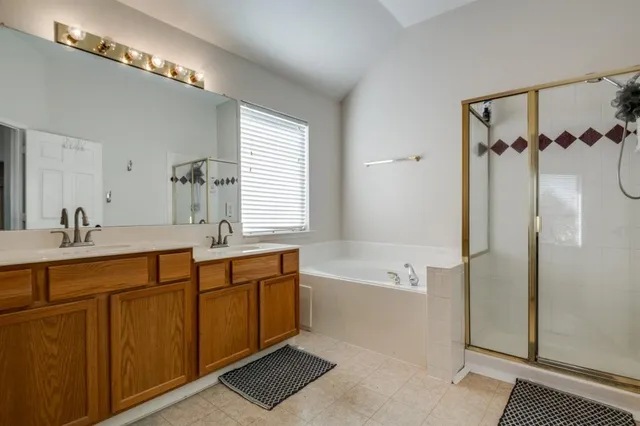 a spacious bathroom with a double vanity sink a mirror and a bathtub