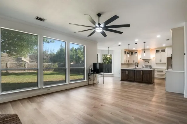 a view of a kitchen with wooden floor and a window