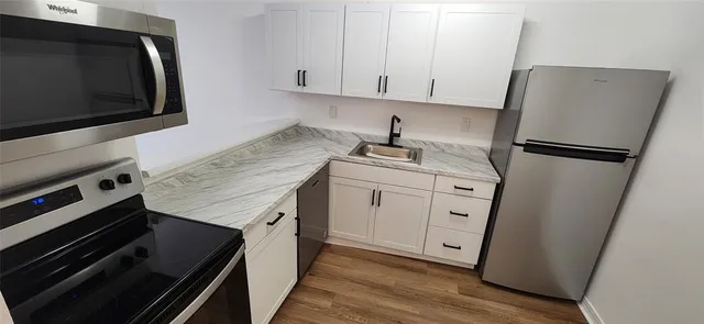 a kitchen with stainless steel appliances a stove microwave and refrigerator