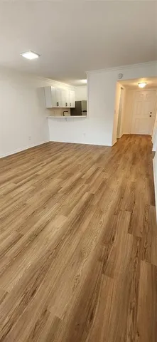 a view of empty room with wooden floor