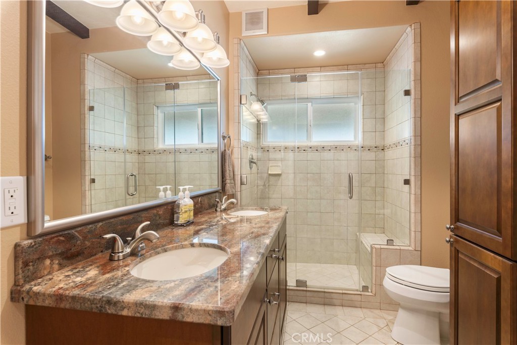 3103 Manzanita Road Kelseyville, CA 95451 - Photo 34 of 62 a bathroom with a granite countertop sink a toilet a mirror and shower