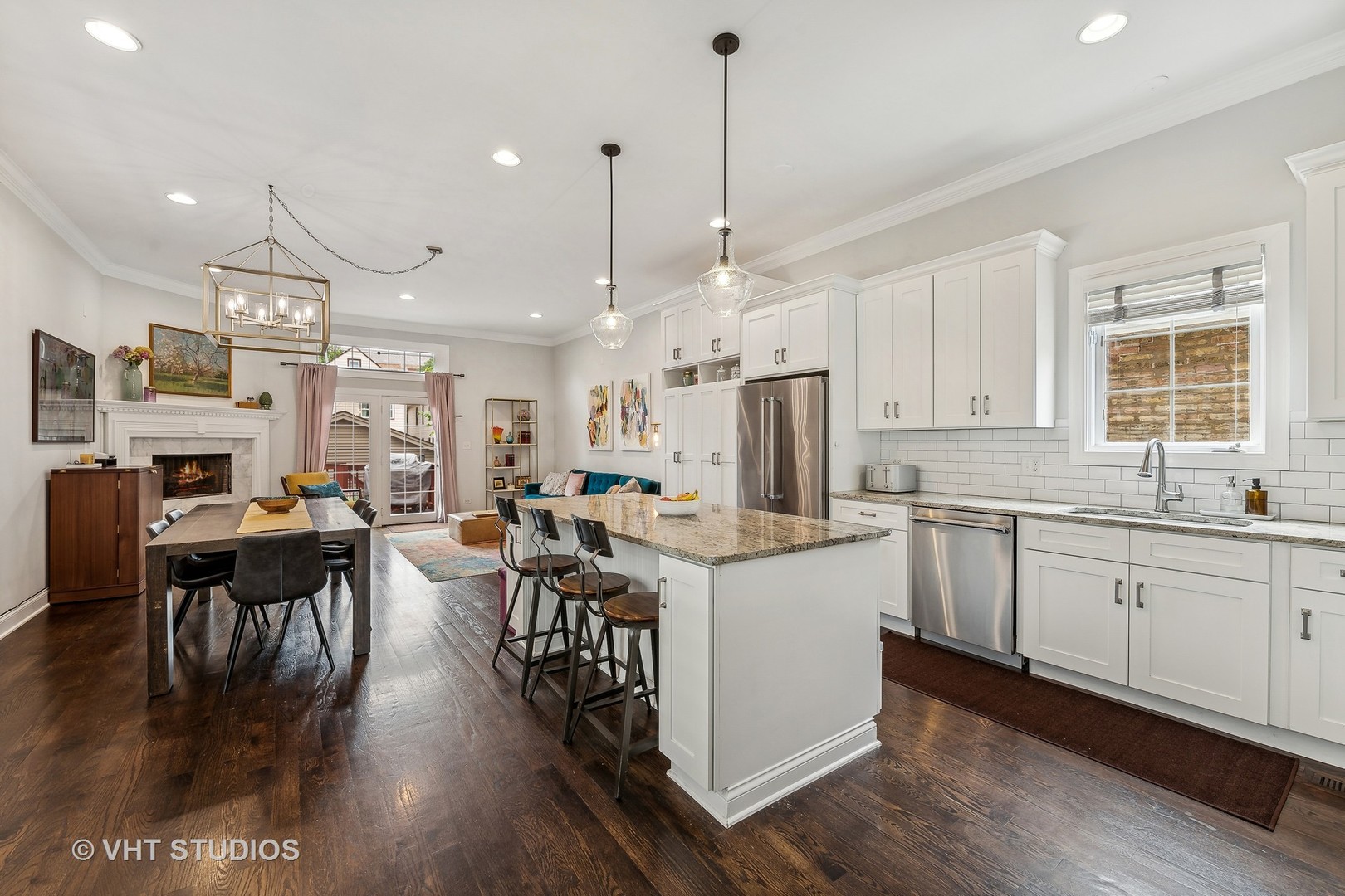 3409 North Ridgeway Avenue Chicago, IL 60618 - Photo 10 of 37 a kitchen with stainless steel appliances kitchen island granite countertop a stove a refrigerator a kitchen island a dining table and chairs with wooden floor