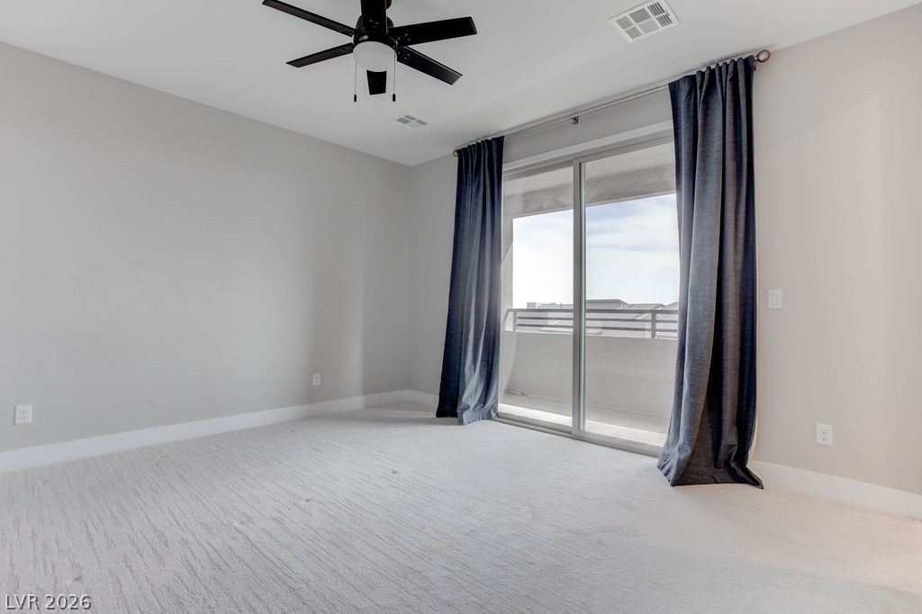 646 Infinity Rdg Street Las Vegas, NV 89138 - Photo 16 of 40 Primary bedroom #1 with a private balcony, ceiling fan and drapes