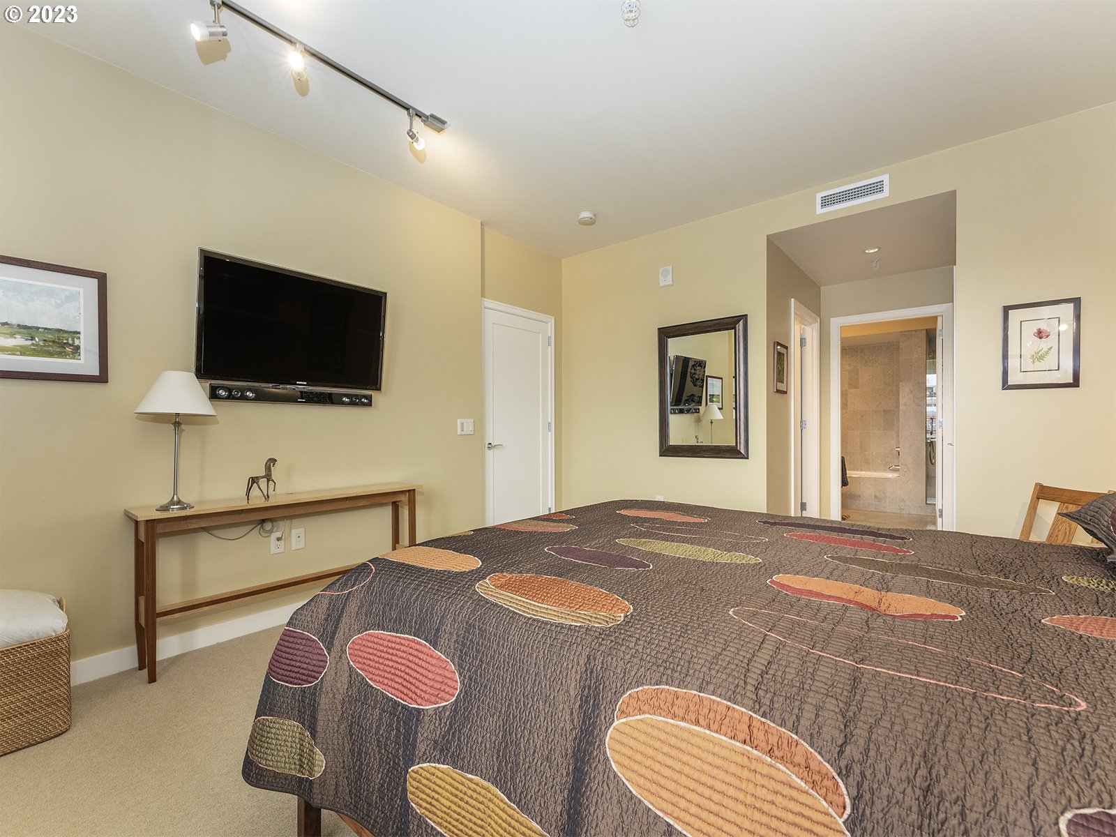 841 Southwest Gaines Street, Unit 1912 Portland, OR 97239 - Photo 22 of 32 a bedroom with a bed and a flat screen tv