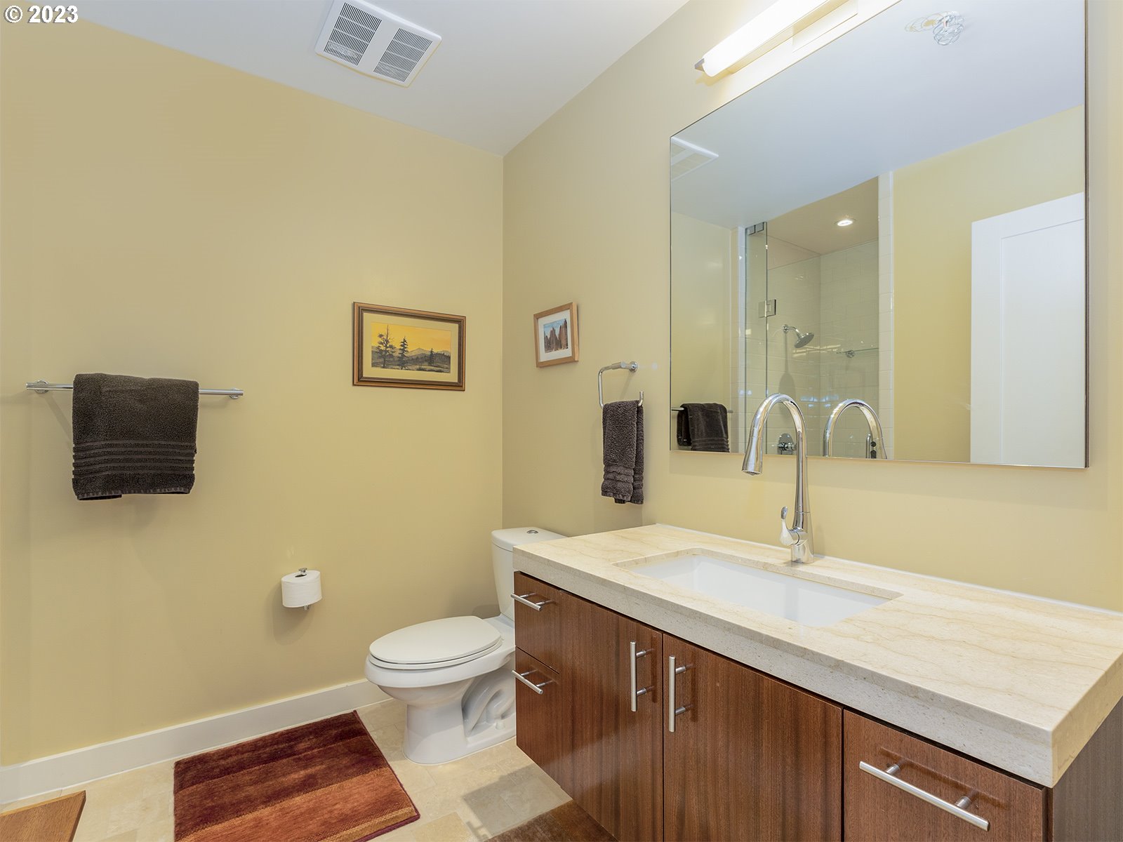 841 Southwest Gaines Street, Unit 1912 Portland, OR 97239 - Photo 28 of 32 a bathroom with a granite countertop sink a toilet and a mirror
