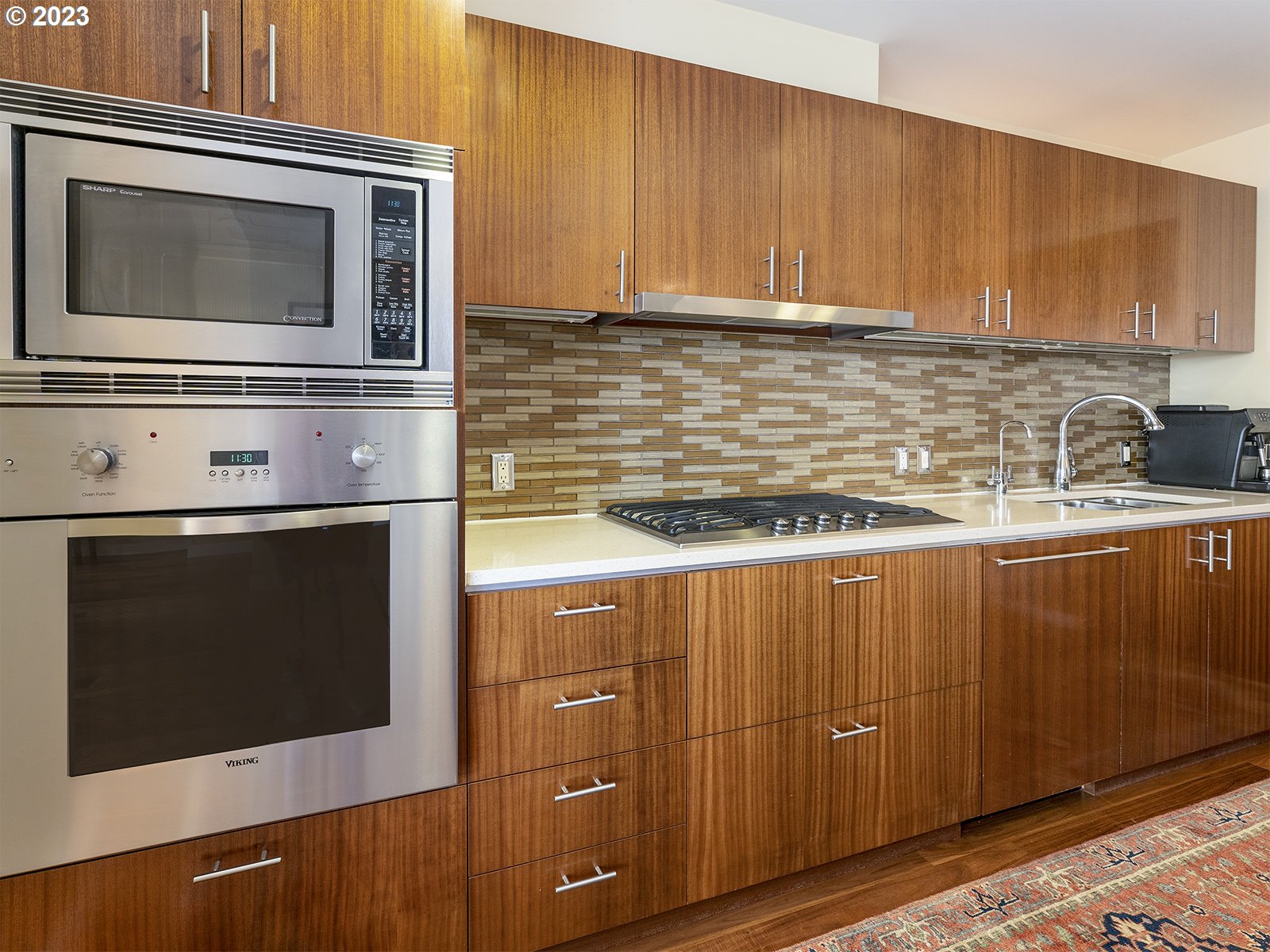 841 Southwest Gaines Street, Unit 1912 Portland, OR 97239 - Photo 6 of 32 a kitchen with granite countertop cabinets stainless steel appliances and wooden floor