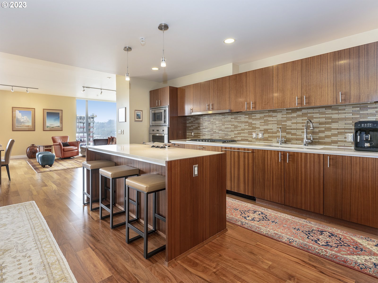 841 Southwest Gaines Street, Unit 1912 Portland, OR 97239 - Photo 9 of 32 a kitchen with stainless steel appliances granite countertop a stove top oven a sink dishwasher and cabinets with wooden floor