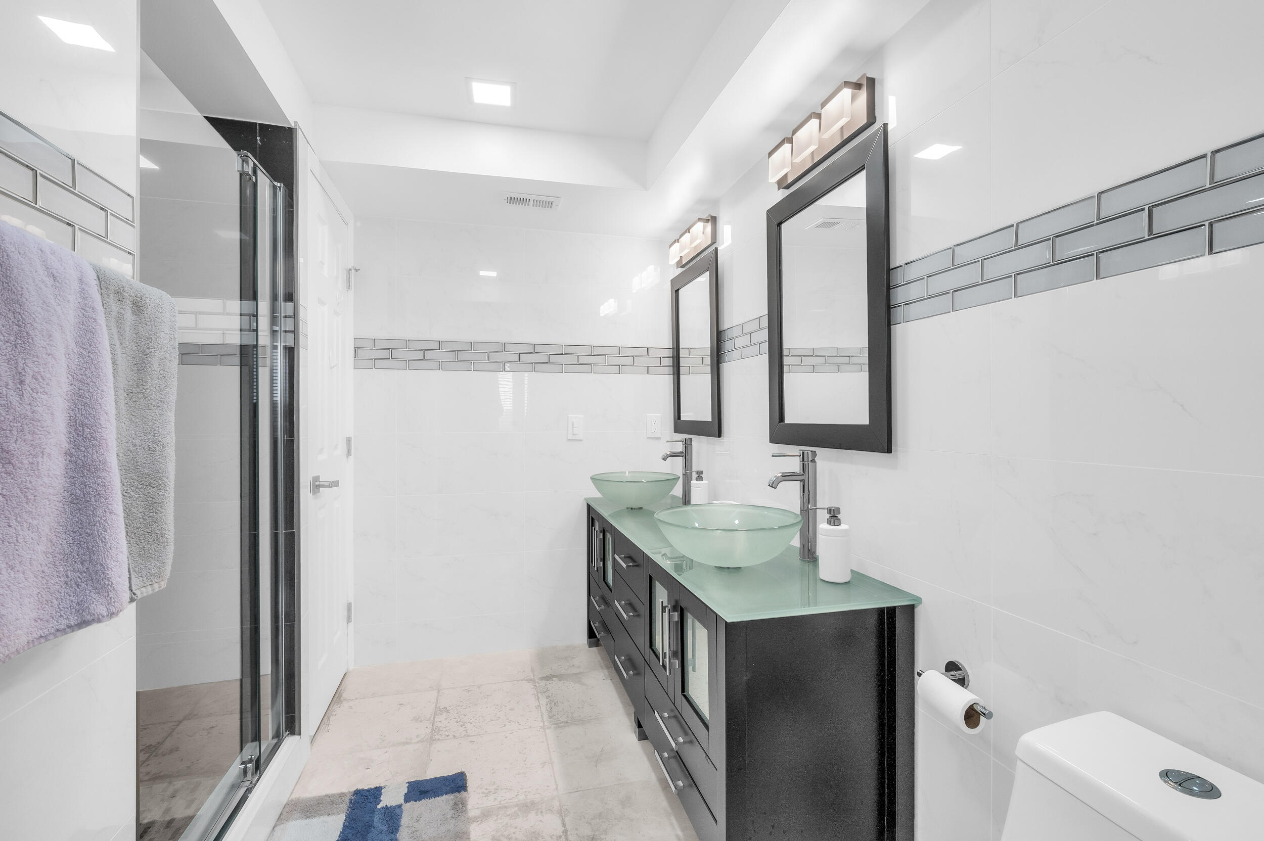 14475 Strathmore Lane, Unit 602 Delray Beach, FL 33446 - Photo 12 of 28 a bathroom with a double vanity sink toilet and mirror