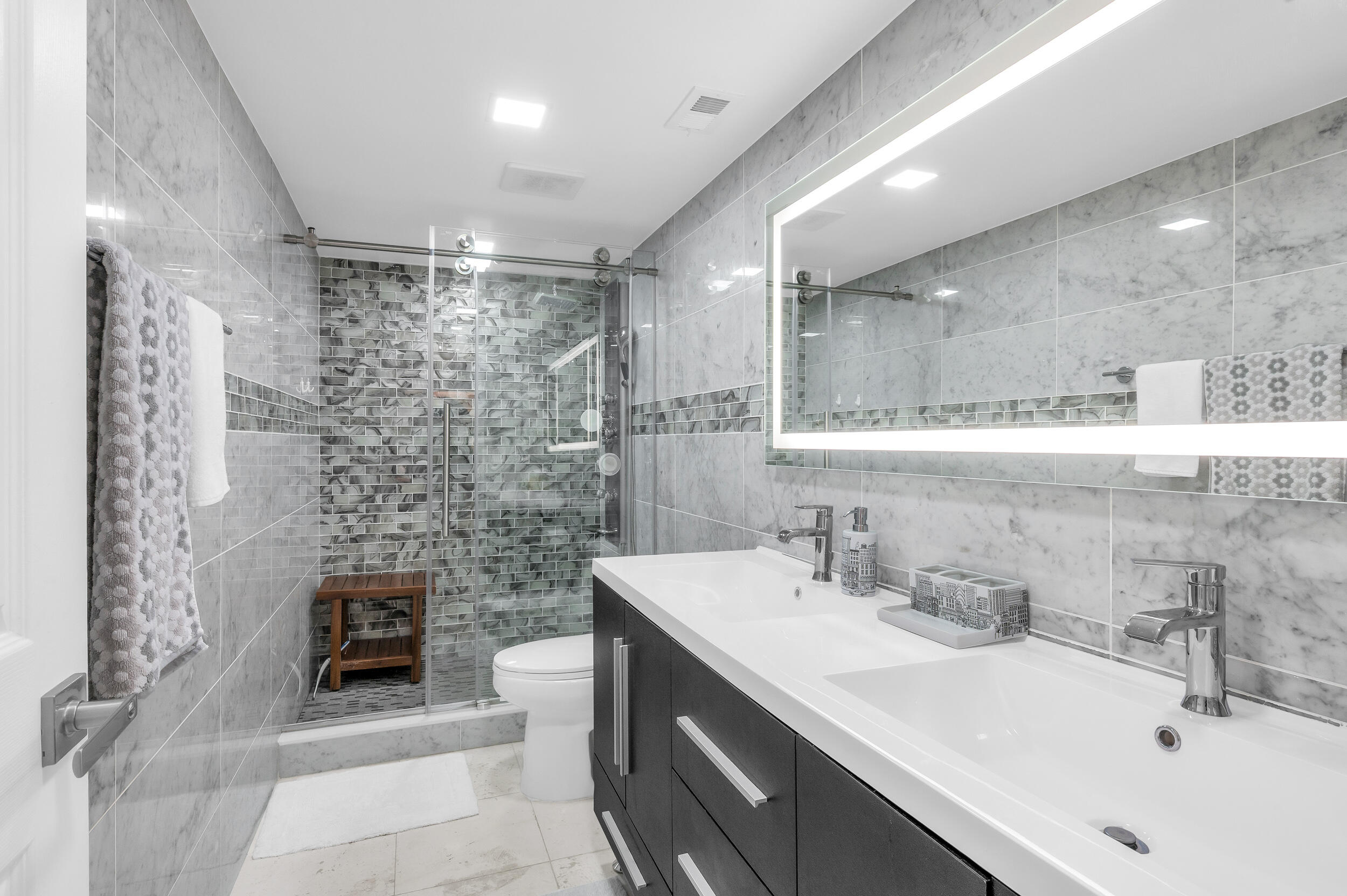 14475 Strathmore Lane, Unit 602 Delray Beach, FL 33446 - Photo 14 of 28 a bathroom with a sink a toilet a mirror and shower