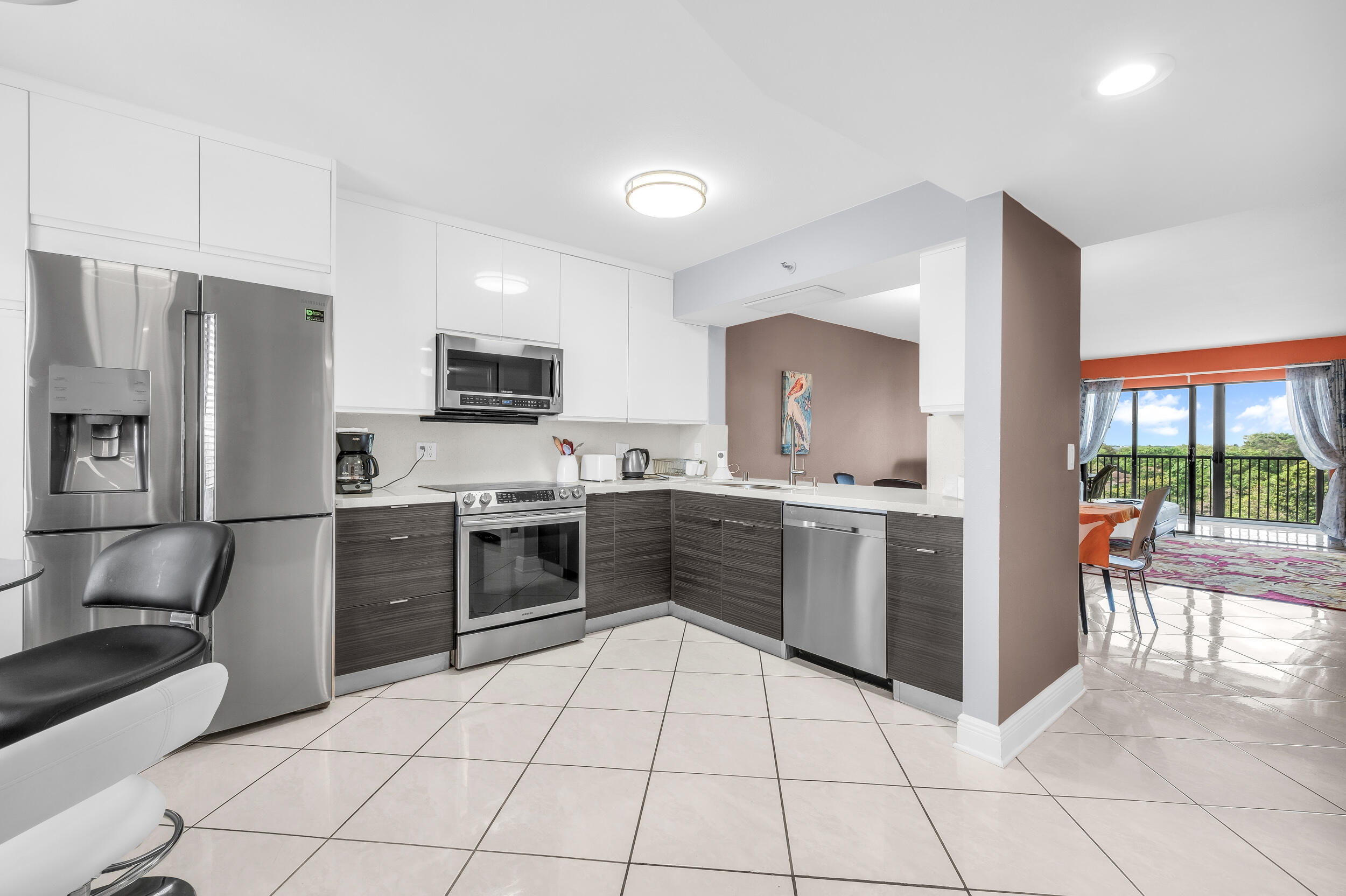 14475 Strathmore Lane, Unit 602 Delray Beach, FL 33446 - Photo 2 of 28 a kitchen with stainless steel appliances a stove a sink and a refrigerator