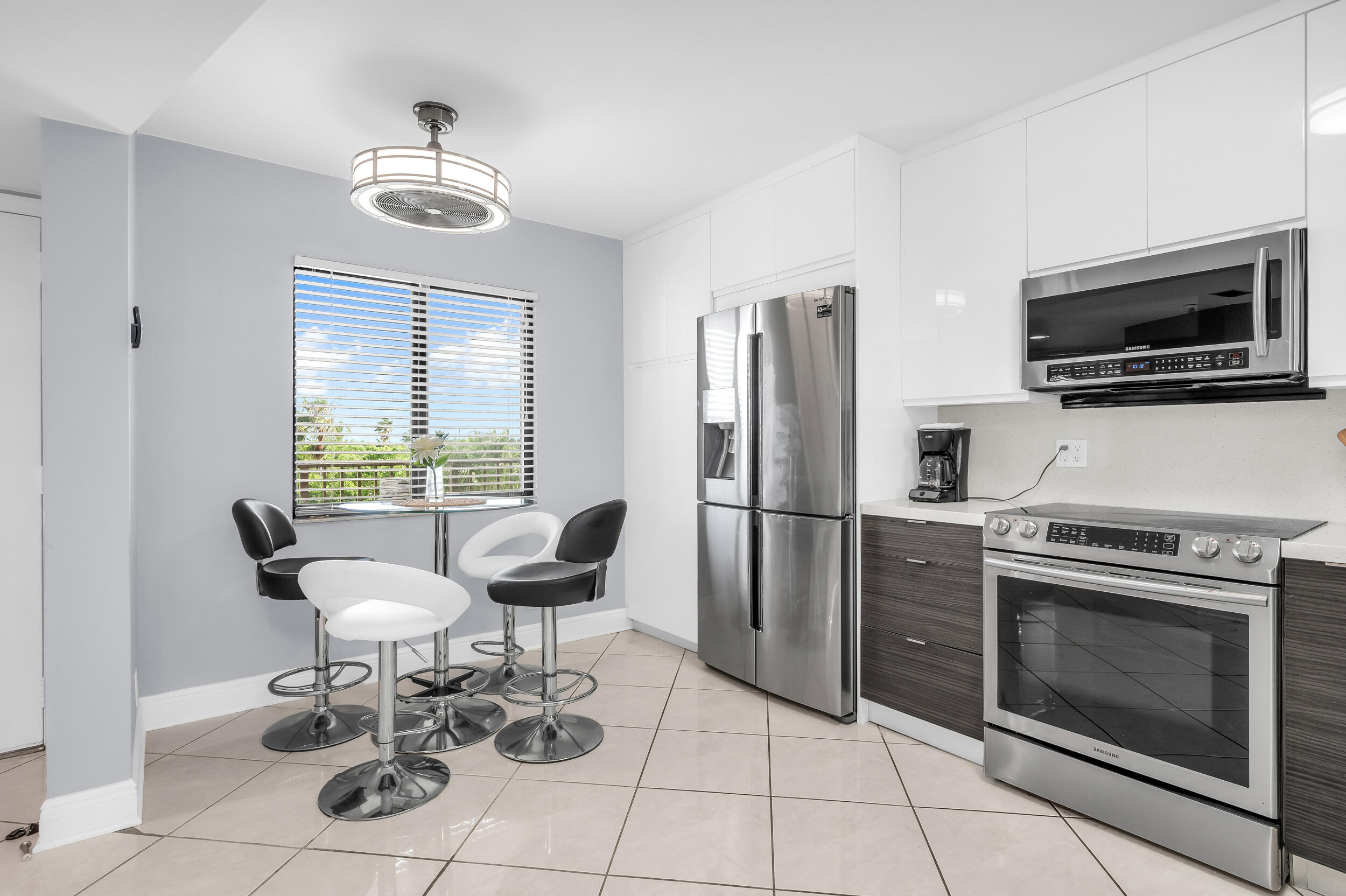 14475 Strathmore Lane, Unit 602 Delray Beach, FL 33446 - Photo 5 of 28 a kitchen with stainless steel appliances a stove a microwave and a refrigerator