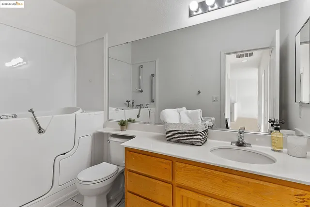 a bathroom with a granite countertop toilet sink and mirror